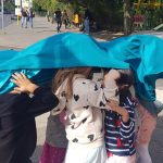Kinder im öffentlichen Raum, die ihre Köpfe mit einer Decke bedecken